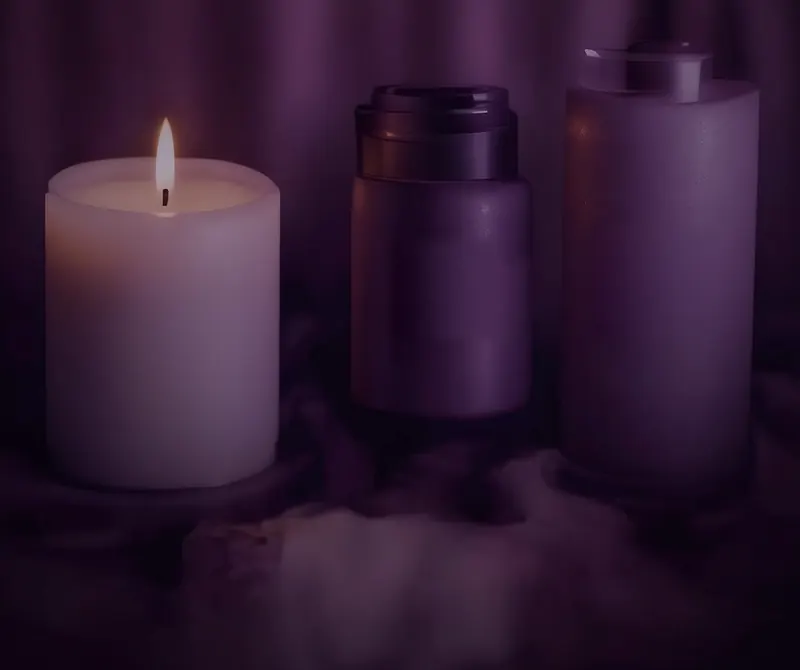 Candle and self-care bottles in soft purple light
